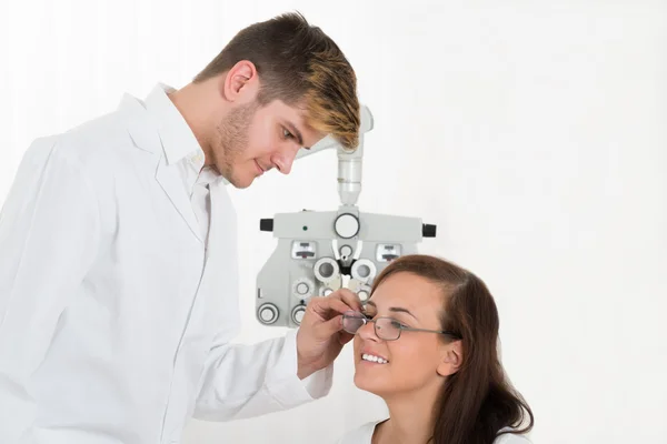 Optiker trägt Brille zur Frau — Stockfoto