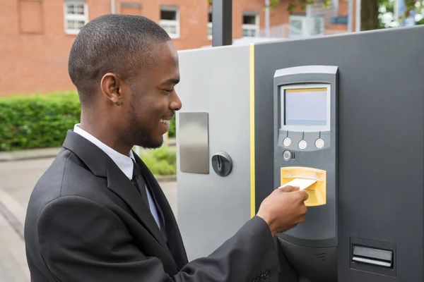 Homme d'affaires insérant le billet dans la machine de stationnement — Photo