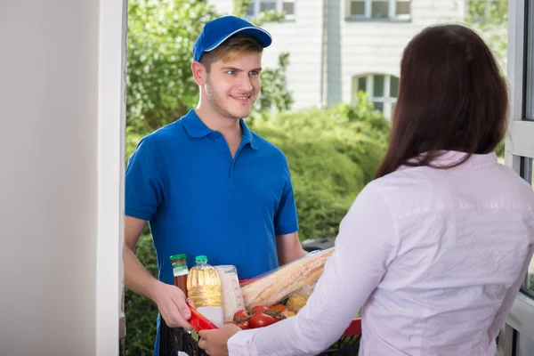 Kvinna får matvaror från leverans Man — Stockfoto