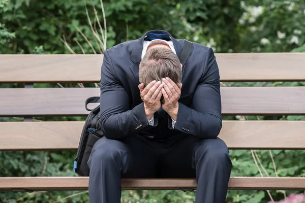 Smutné, podnikatel, sedí na lavičce — Stock fotografie