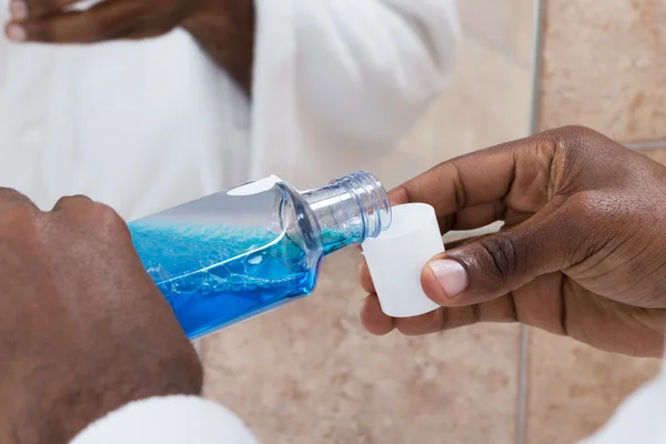 Person Hands Pouring Mouthwash Into Bottle Cap — Stock Photo, Image