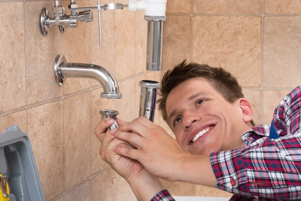 Installateur montiert Waschbecken-Rohr im Badezimmer — Stockfoto