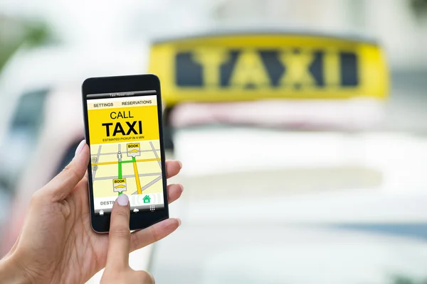 Ручной холдинг Мобильный телефон бронирования такси — стоковое фото