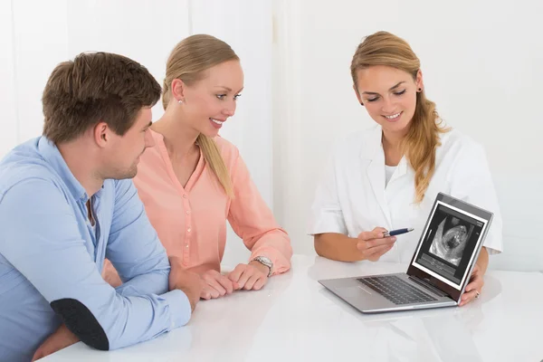 Médico mostrando ultra-som de bebê para casal — Fotografia de Stock