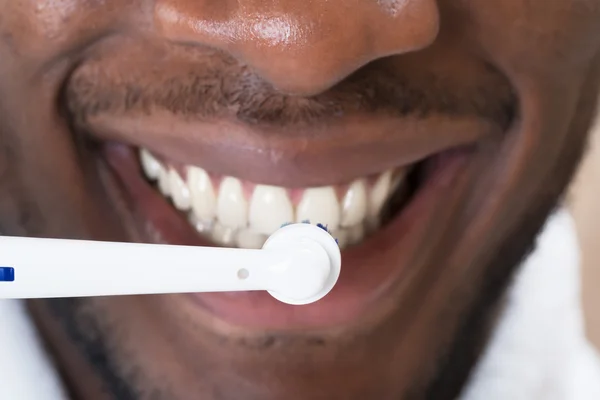 Close-up de um homem africano limpando seus dentes — Fotografia de Stock