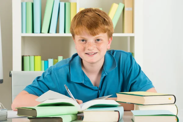 Felice ragazzo studiare in biblioteca — Foto Stock