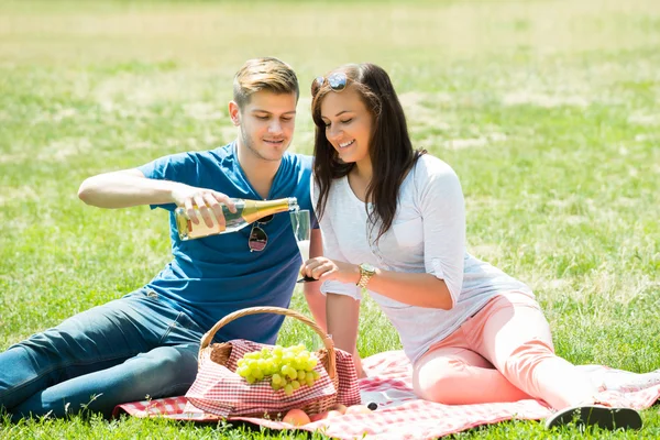 Man glas Champagne binnenstromen voor vrouw — Stockfoto