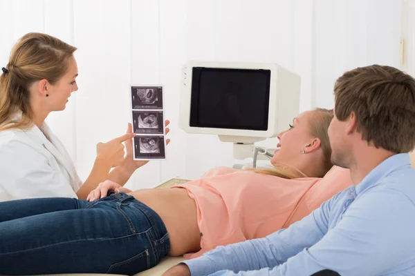 Médico mostrando ultra-som para a mulher grávida — Fotografia de Stock