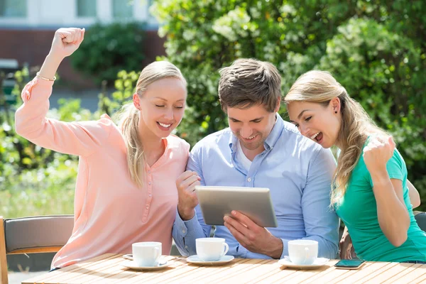 Gruppe aufgeregter Freunde schaut auf digitales Tablet — Stockfoto