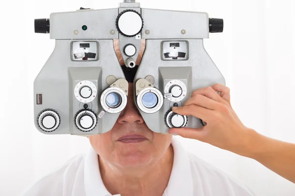 Optometrist stellt Phoropter für Patienten ein — Stockfoto