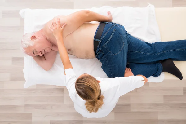 Masseur Massage op Senior Man doen — Stockfoto