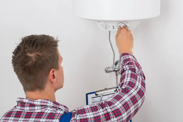 Mannelijke loodgieter aanpassing van temperatuur van elektrische Boiler — Stockfoto