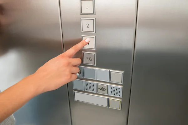 Mano presionando el botón del primer piso en el elevador —  Fotos de Stock