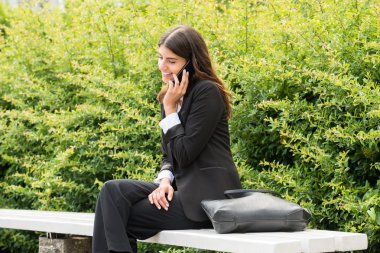 Tezgah üzerinde cep telefonu konuşurken üzerinde oturan işkadını