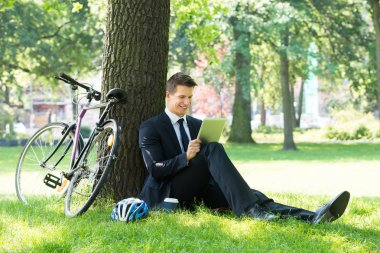 parkta dijital tablet kullanarak iş adamı
