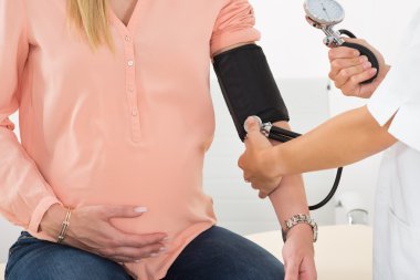 Erkek doktor hamile kadının kan basıncı kontrol