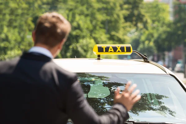 Бизнесмен, вызывающий такси — стоковое фото