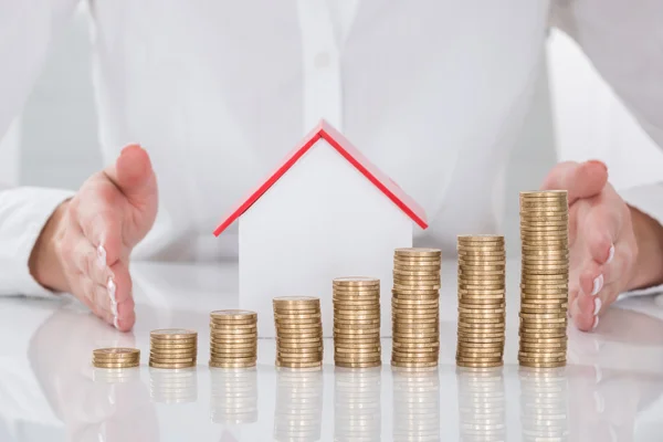 Businesswoman Protecting Coins And House Model — Stock Photo, Image