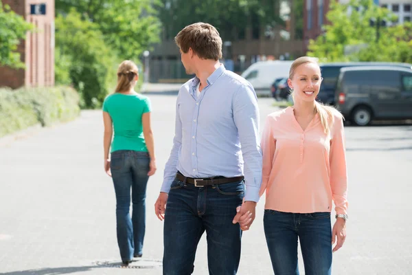 Uomo a piedi con la sua ragazza guardando un altro donna — Foto Stock