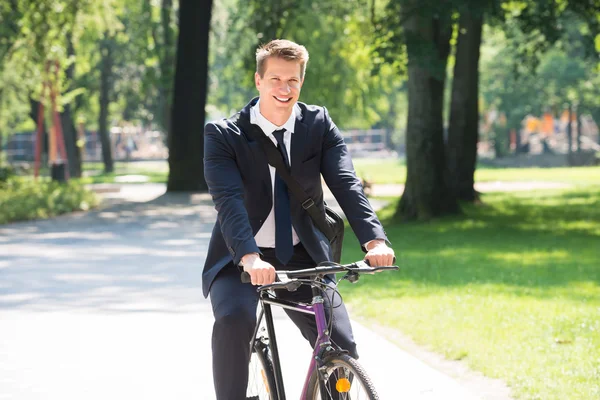 Homme d'affaires à vélo dans le parc — Photo