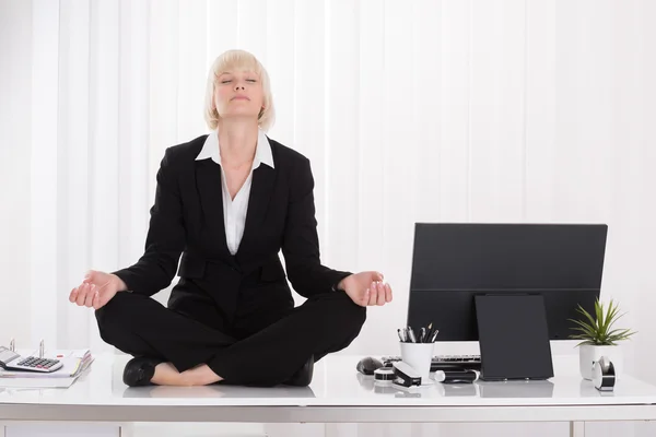İş kadını ofiste yoga yaparken — Stok fotoğraf