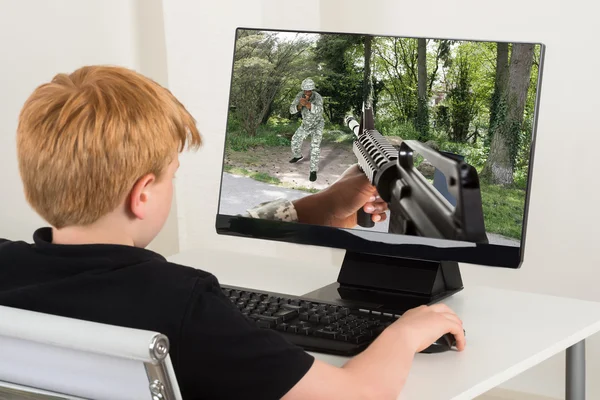 Menino jogando jogo de ação no computador — Fotografia de Stock