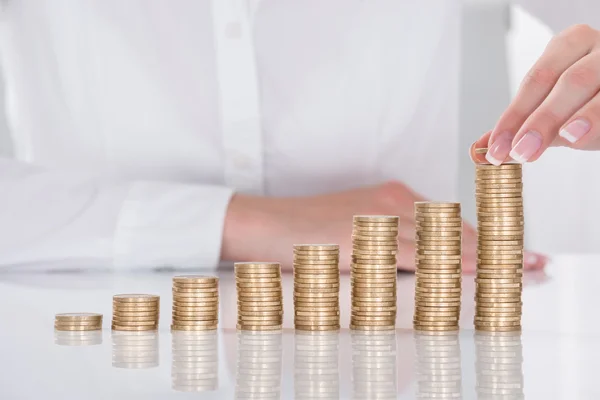 Affärskvinna Hand att placera mynt över stacken av mynt — Stockfoto