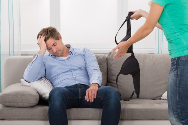 Astonished Wife Holding Bra And Showing It To Her Husband