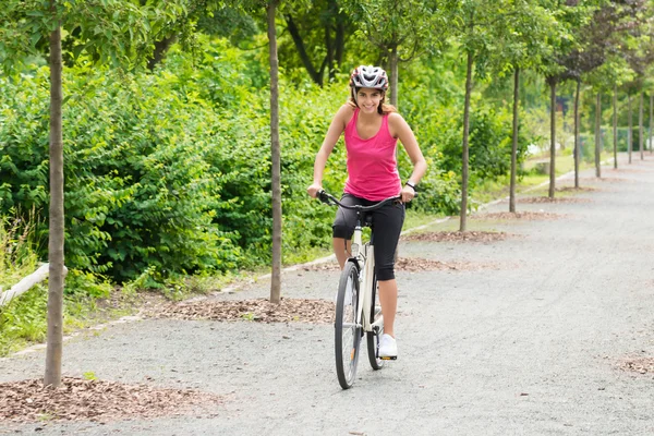 Молода жінка насолоджується їздою на велосипеді — стокове фото