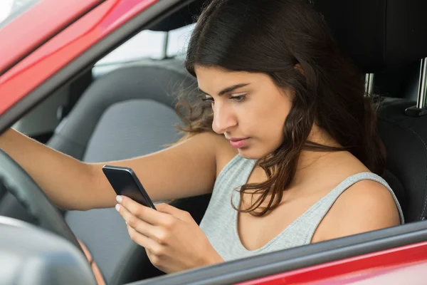 Женщина с мобильным телефоном в машине — стоковое фото