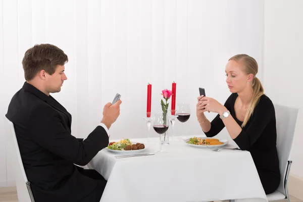 Pareja mirando sus teléfonos móviles —  Fotos de Stock