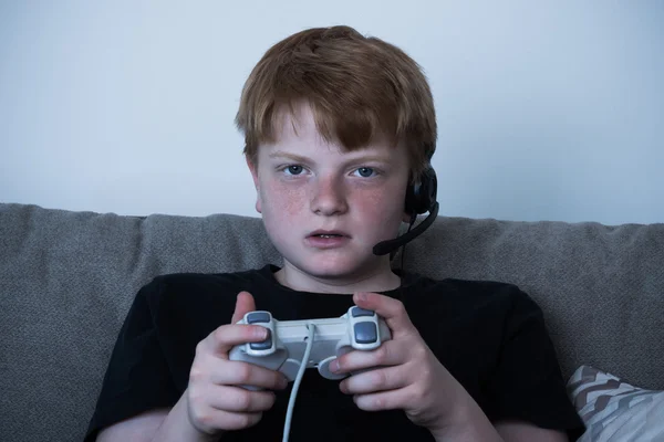 Niño con un joystick jugando videojuegos — Foto de Stock