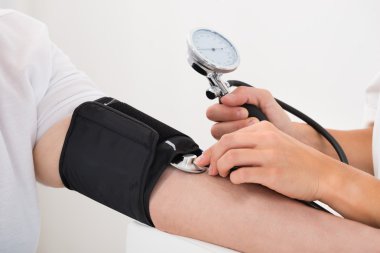 Doktor hastanın kan basıncını kontrol