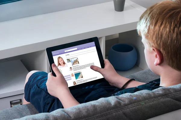 Jongen met behulp van Social Networking Site op digitale Tablet — Stockfoto
