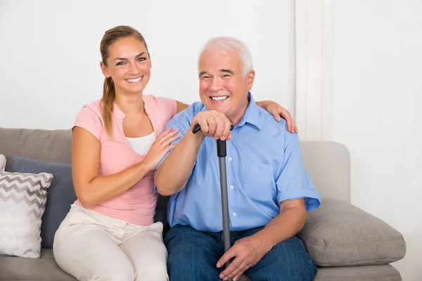 Woman With Her Disabled Father Sitting On Sofa — Stock Photo, Image