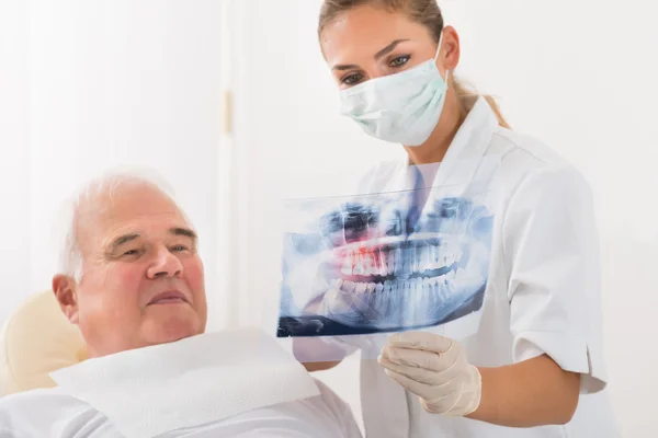 Medico mostrando radiografia dentale al paziente maschio — Foto Stock