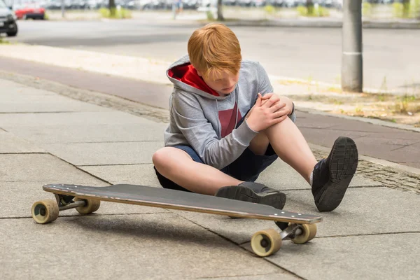 Niño mirando a su pierna lesionada —  Fotos de Stock