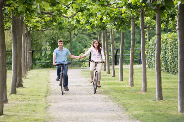 Το ευτυχισμένο ζευγάρι ποδήλατο στο πάρκο — Φωτογραφία Αρχείου