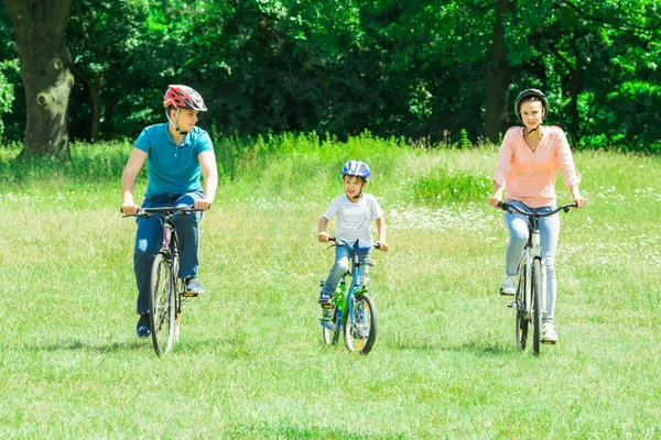 Garçon avec des parents vélo d'équitation — Photo