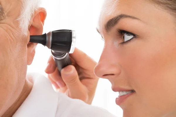 Kvinna läkare undersöka patientens öra — Stockfoto