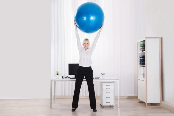 Imprenditrice che allunga le braccia in ufficio — Foto Stock