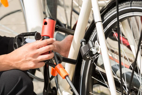 Femme d'affaires main verrouillage de son vélo — Photo