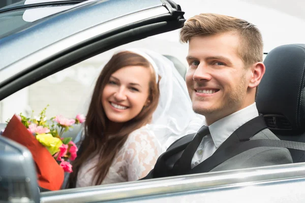 Giovane appena sposato coppia in auto — Foto Stock