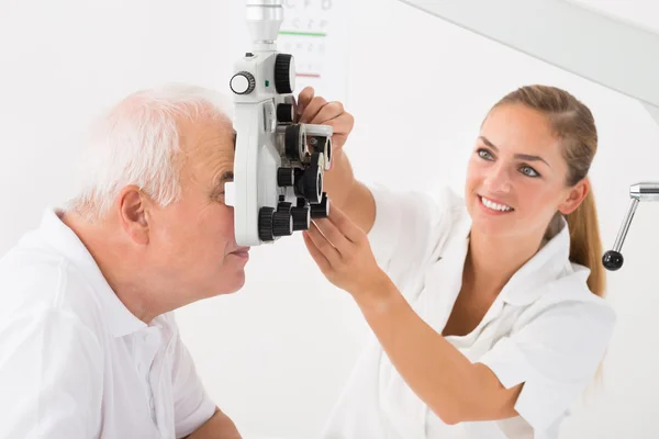 En optiker som gör syn testning för patienten — Stockfoto