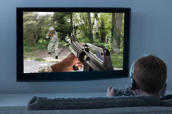 Menino jogando jogo de ação na televisão — Fotografia de Stock