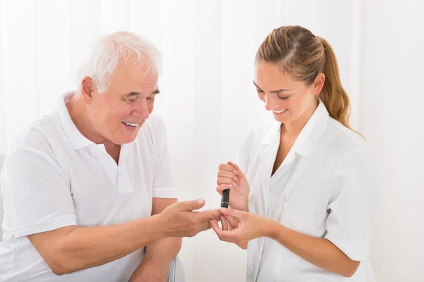Medico Utilizzando Lancelet sul dito del paziente — Foto Stock