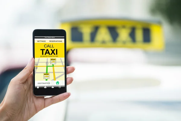 Mano femminile che tiene il cellulare Prenotazione Taxi — Foto Stock