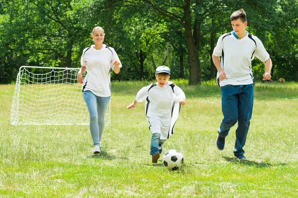 Família feliz jogando futebol — Fotografia de Stock