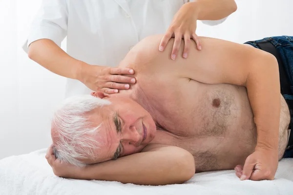 Terapist masaj için üst düzey erkeğe veriyor — Stok fotoğraf