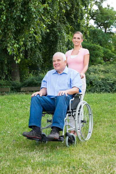 Donna con suo padre disabile sulla sedia a rotelle — Foto Stock